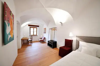 a bedroom with a bed and a desk in a room at Casa Piganò in Appiano sulla Strada del Vino