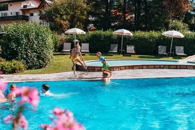 a group of children playing in a swimming pool at Family Hotel Posta in Santa Cristina in Val Gardena