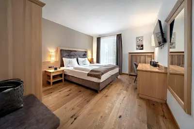 a hotel room with a bed and a television at Family Hotel Posta in Santa Cristina in Val Gardena