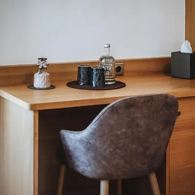 a desk with a chair and a table with a radio at Family Hotel Posta in Santa Cristina in Val Gardena