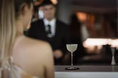 a woman sitting at a table with a glass of wine at Hotel Winkler Sport & Spa Resort in San Lorenzo di Sebato