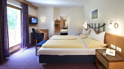 a hotel room with a large bed and a desk at Hotel Bergblick in Racines