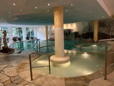 a swimming pool with a column in a building at Hotel Bergblick in Racines