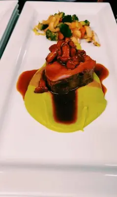 a plate of food with a piece of meat and vegetables at Hotel Bergblick in Racines
