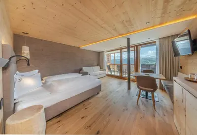 a bedroom with two white beds and two lamps at Nature Hotel Delta in Colfosco