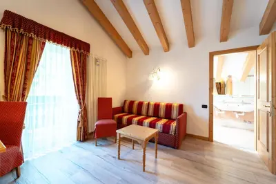 a living room with a couch and a table at Hotel Laurin in Canazei