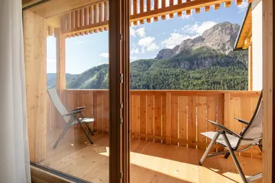 a room with two chairs and a large window at Declara B&B and apartaments in Colfosco