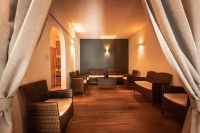 a waiting room with wicker chairs and tables at Hotel Gissbach in Brunico
