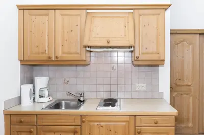 a kitchen with wooden cabinets and a sink at Appartements Eppanerhof in Appiano sulla Strada del Vino