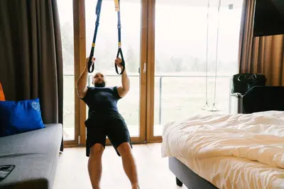 a woman is hanging from ropes in a hotel room at Hotel Wochtla Buam Aktivhotel am Kronplatz mit Sauna in Brunico
