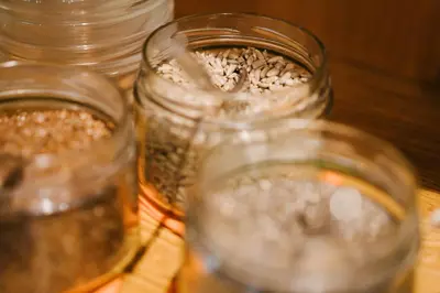 four glass jars filled with food on a table at Hotel Wochtla Buam Aktivhotel am Kronplatz mit Sauna in Brunico