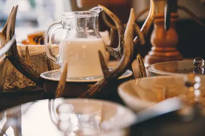 a glass jug of milk on a table with dishes at Albergo Centrale in San Martino di Castrozza