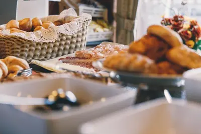 a table with baskets of bread and pastries on it at Albergo Centrale in San Martino di Castrozza