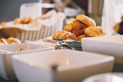 a table with a plate of donuts and a plate of bread at Albergo Centrale in San Martino di Castrozza