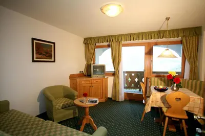 a hotel room with a bed and a table and a window at Residence Riposo in Colfosco