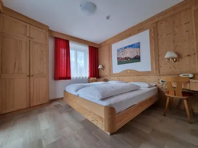 a bedroom with a bed and a desk and a table at Residence Riposo in Colfosco