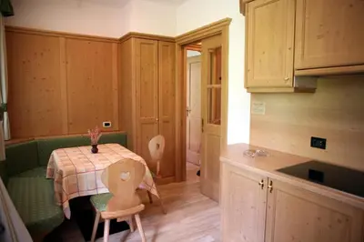 a kitchen with a table and chairs in a room at Residence Riposo in Colfosco