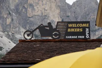 a sign on top of a building with a motorcycle sign at Monti Pallidi B&B Apartments in Corvara in Badia