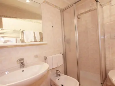a bathroom with a shower and a sink and a toilet at Ciasa Parom in San Cassiano