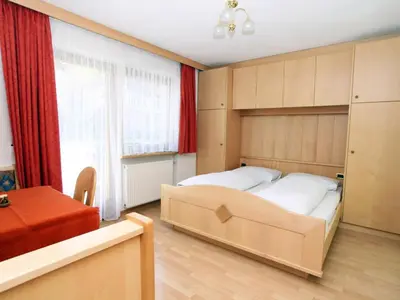 a bedroom with a large bed and a window at Ciasa Parom in San Cassiano