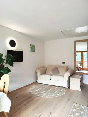 a living room with a white couch and a tv at Ciasa Parom in San Cassiano