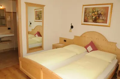 a bedroom with two beds and a mirror at Residence Ciasa Dl Mone in Colfosco