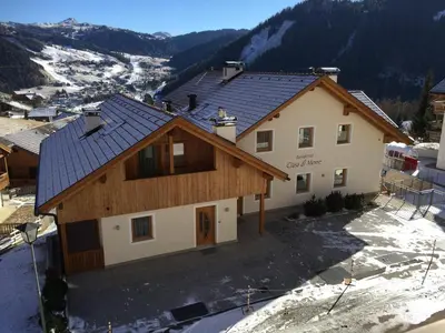 a house with a roof with snow on the ground at Residence Ciasa Dl Mone in Colfosco