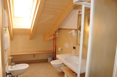 a bathroom with a sink and a toilet and a window at Residence Ciasa Dl Mone in Colfosco
