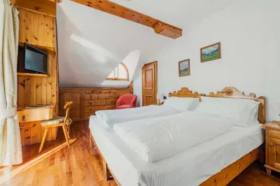 a bedroom with a large white bed and a television at Franceschi Park Hotel in Cortina dʼAmpezzo