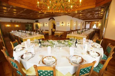 a large dining room with long tables and chairs at Franceschi Park Hotel in Cortina dʼAmpezzo