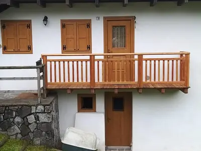 a wooden deck on the side of a building at Casa Lausen in Canale San Bovo