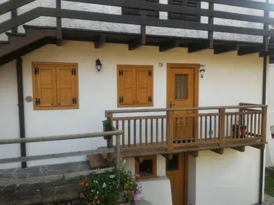 a house with wooden doors and a balcony at Casa Lausen in Canale San Bovo