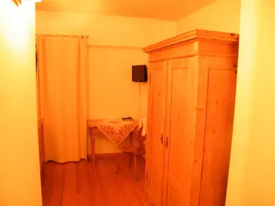 a small room with a table and a wooden cabinet at Agriturismo Fattoria Meneguto Societa Agricola Semplice in Cortina dʼAmpezzo