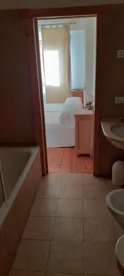 a bathroom with a tub and a bedroom with a bed at Agriturismo Fattoria Meneguto Societa Agricola Semplice in Cortina dʼAmpezzo