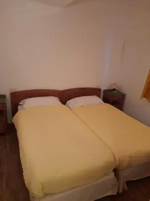 a bedroom with two beds and two night stands at Agriturismo Fattoria Meneguto Societa Agricola Semplice in Cortina dʼAmpezzo