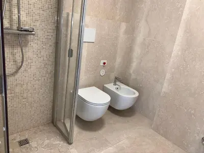 a bathroom with a toilet and a shower and a sink at Hotel Serena Cortina in Cortina dʼAmpezzo