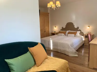 a bedroom with a bed and a couch next to a bed at Hotel Serena Cortina in Cortina dʼAmpezzo
