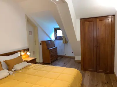 a bedroom with a large yellow bed and a television at Hotel Serena Cortina in Cortina dʼAmpezzo