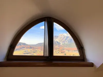 an arched window with a view of a mountain at Hotel Serena Cortina in Cortina dʼAmpezzo
