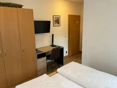 a bedroom with a desk with a computer and a bed at Alpenblick Bed & Breakfast in Vipiteno