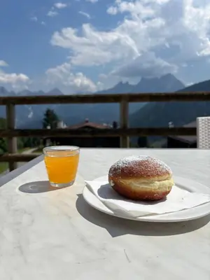 a white plate with a piece of food on a table at HG Hotel La Caminatha in Val di Zoldo