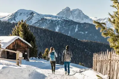 a man and a woman walking in the snow at Hotel Rosental in Luson