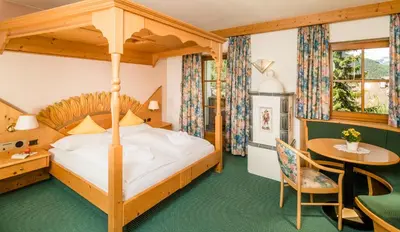 a bedroom with a bed and a table and a desk at Hotel Rosental in Luson
