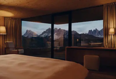 a bedroom with a large window with a mountain view at Forestis Dolomites in Bressanone