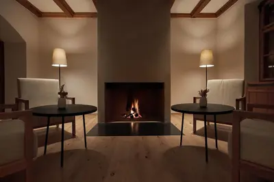 two tables in a living room with a fireplace at Forestis Dolomites in Bressanone