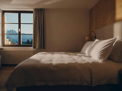 a bedroom with a bed with a large window at Forestis Dolomites in Bressanone