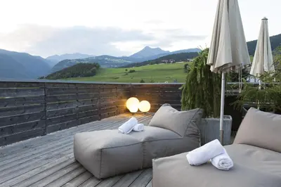 a patio with couches and a view of a mountain at Hotel Tirolerhof in Rodengo