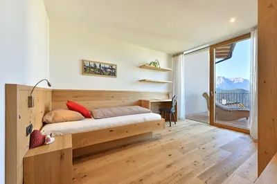 a bedroom with a bed and a desk and a window at Anger living in Laion