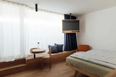 a bedroom with a bed and a table and a window at Haus am Turm in Vipiteno