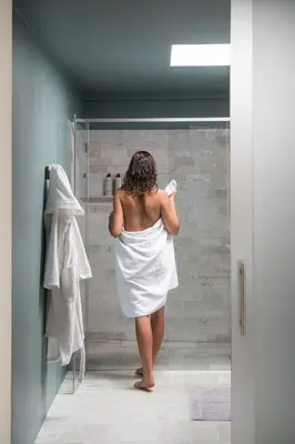 a woman in a white dress standing in a shower at Haus am Turm in Vipiteno